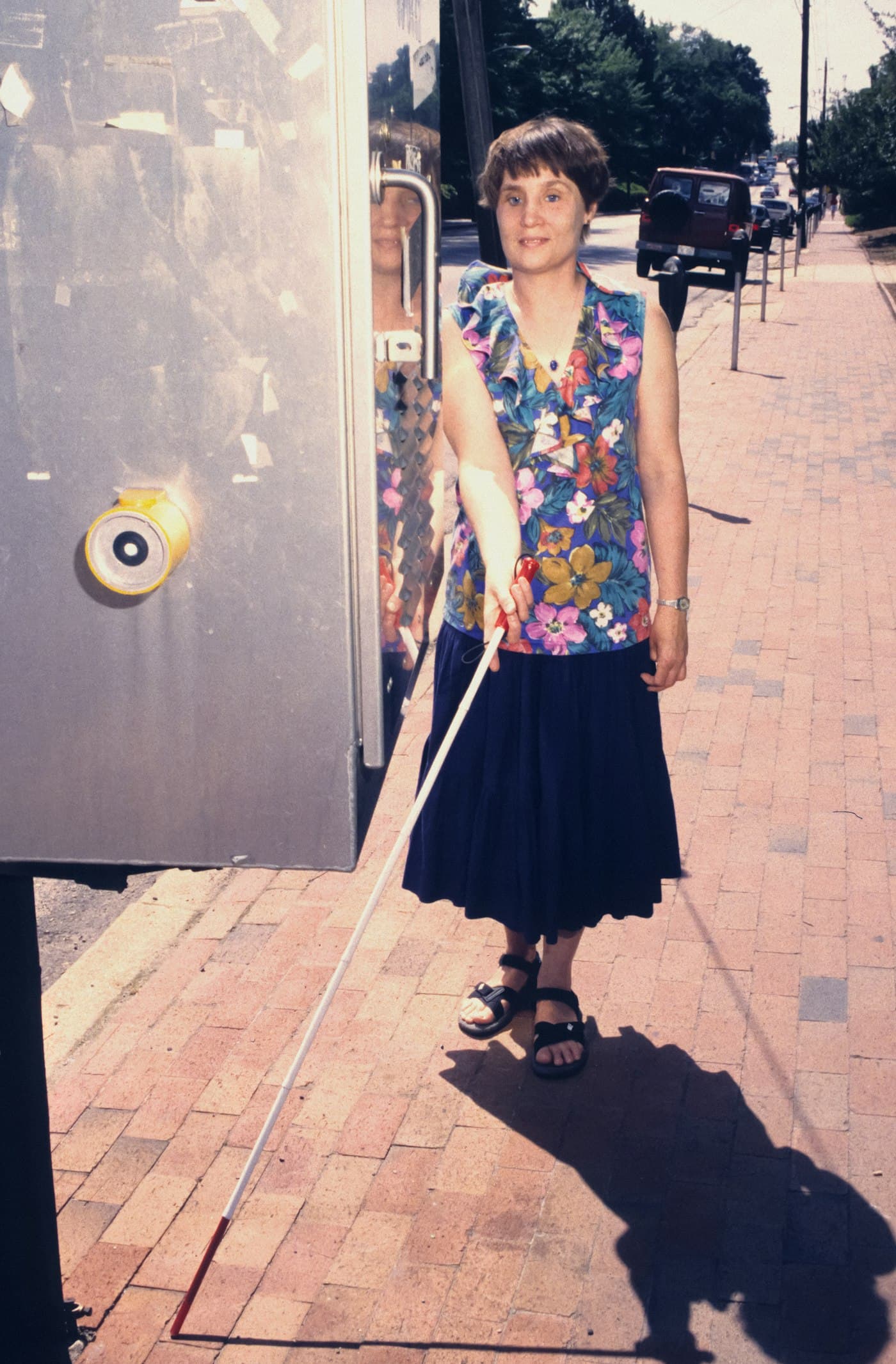 A visually impaired woman navigating independently with a white cane in a public space, representing access to opportunity and economic empowerment